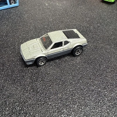 Coche diecast Hot Wheels BMW M-1 Real Riders 1982 rojo con rayas amarillas Malasia Foto 1 de 4