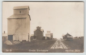 Postcard RPPC Grain Elevators and Train Tracks in Shelby, NE. - Picture 1 of 2