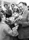 Walt Disney is presented with a bouquet of flowers by an admirer - 1958 Photo