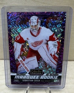 2024-25 O-Pee-Chee Platino Novato Sebastian Cossa Alas Rojas Píxeles Violeta/299 - Imagen 1 de 2