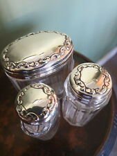 A Set of Three Edwardian Silver-topped Dressing Table Bottles