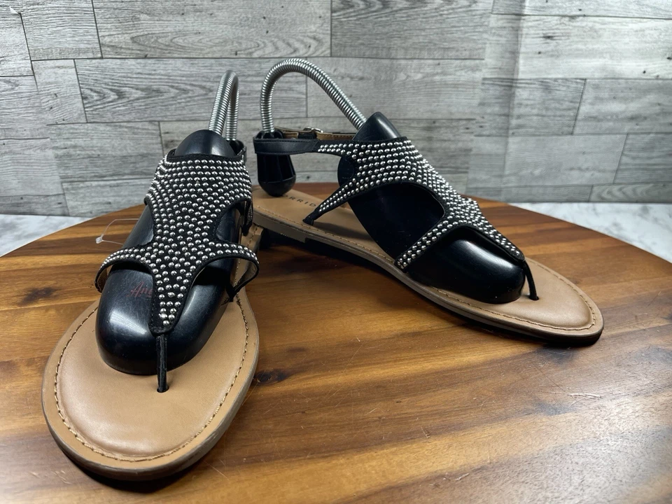 Torrid 凉鞋女式 10W 宽鞋黑色黑色金色皮革铆钉带丁字裤 — 第 1/4 张图片