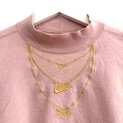 Nike Camiseta Rosa Collar Oro Logo Bordado Suelto Recorte LS Cuello Simulado Mujeres Pequeña Foto 1 de 4