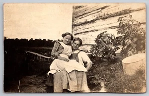 Cartolina RPPC Moglie contadina seduta in grembo alla fattoria WOB | c1910s - Foto 1 di 2