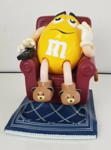 LG YELLOW PEANUT M&M IM LOUNGE CHAIR AUF TEPPICH FERNBEDIENUNG BONBONSPENDER - Bild 1 von 8