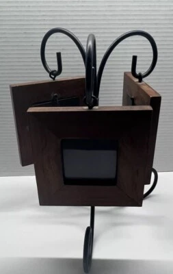 Lindo conjunto de tres pequeños marcos de madera marrón que tienen un soporte de metal negro Foto 1 de 4