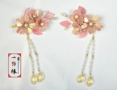 Un par de pinzas para el cabello rosa naranja con pinza para el cabello colgante para niños Foto 1 de 4