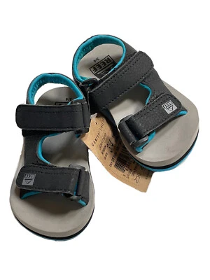 Sandalia tierra/agua nueva con etiquetas Reef Grom Stomper niño pequeño EE. UU. 3/4 correa de duelo negra/verde azulada/gris Foto 1 de 4