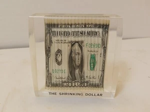 Ancien presse papier lucite "DOLLAR RÉTRÉCISSANT" - billet de 1 $ accordéon 3"x3" - Photo 1/10