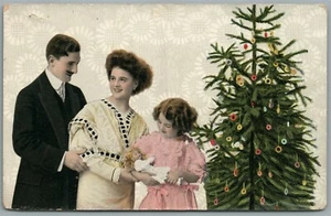 FAMILY w/ CHRISTMAS TREE & GIRL w/ DOLL ANTIQUE POSTCARD - Picture 1 of 2