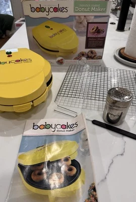 Babycakes Antiadherente 6 Mini Donut Maker Amarillo Estante Tenedor Coctelera Recetas Juego de Caja Foto 1 de 4