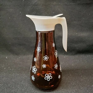 Dispensador de jarabe de colección vidrio marrón humo con flores blancas tapa blanca cabina de troncos - Imagen 1 de 6