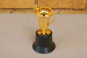 Kleine Auszeichnung kleine goldfarbene Gewinner Pokal Trophäe Puppengröße Geschenk Witz Spaß GX - Bild 1 von 5