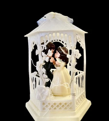 Cinta y flores vintage de arco de campana de novia y novio con adorno de pastel de boda años 70 Foto 1 de 4