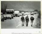 Press Photo Mike Byrd and fellow hikers walking on the road in Anchorage