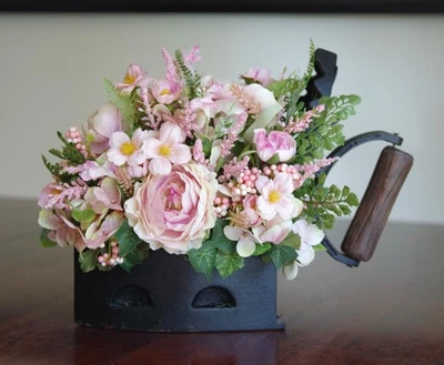 Hierro de carbón vintage con arreglo de seda rosa de Ranúnculo, cosmos e hortensias Foto 1 de 4