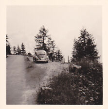 Foto - junger Mann neben alten Auto, PKW, Oldtimer, VW Käfer im Gebirge
