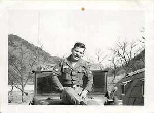 Foto instantánea en blanco y negro 1960 soldado del ejército de Corea de Estados Unidos sentado en el capó del camión del ejército - Imagen 1 de 1