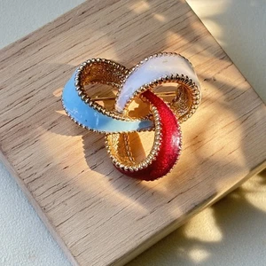 Broche prendedor vintage Ciner rojo blanco azul esmalte lazo entrelazado tono dorado RARO - Imagen 1 de 6