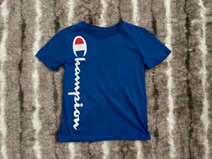 Camiseta deportiva Champion con logotipo con guión para niños en azul talla pequeña - Imagen 1 de 2