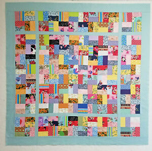 An unfinished Truly Scrappy quilt top measuring approx 44.5 x 44.5 inches