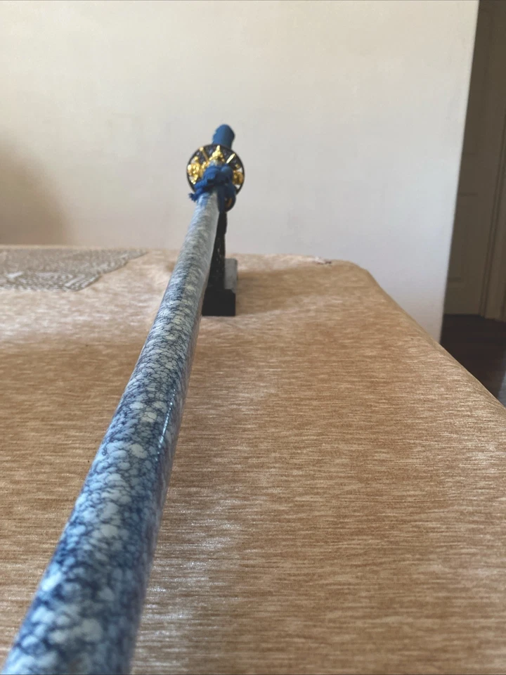 Una katana azul con una cara de monstruo impresa en ella extremadamente nítida y hermosa Foto 1 de 4