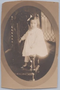 Foto antigua niña pequeña con arco grande en silla tallada ornamentada retrato de 1900 - Imagen 1 de 2