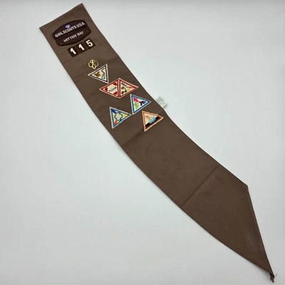 Faixa marrom escoteira vintage com emblemas anexados e adesivos soltos, início dos anos 90 - Imagem 1 de 4