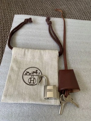 Candado y bolsa HERMES Clochette marrón con cerradura plateada y llaves casi como nuevo Foto 1 de 4