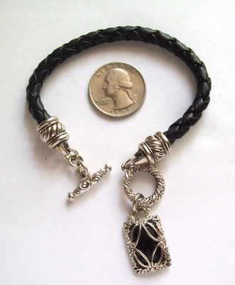 Pulsera trenzada de cuero negro con dije colgante tono plateado y negro Foto 1 de 4