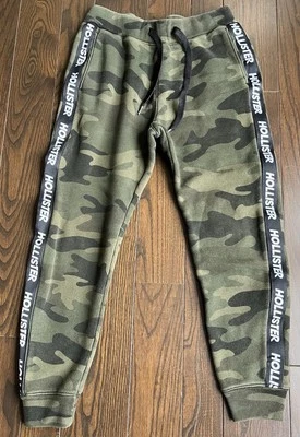 Pantalones deportivos Hollister verdes camuflados logotipo a rayas deletreado cónico para hombre XS Foto 1 de 4