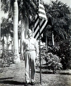 Vintage 1942 WWII B&W Photograph American Soldier Posing Flag Dated Scalloped - Picture 1 of 3