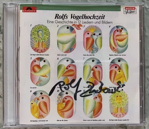 ORIGINAL Autogramm von Rolf Zuckowski. Auf CD Cover. "EINE GESCHICHTE IN 12 L.." - Picture 1 of 1