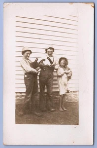 1910 Kinder halten Haustier Kaninchen machen lustige Gesichter Echtfoto RPPC Postkarte - Bild 1 von 2