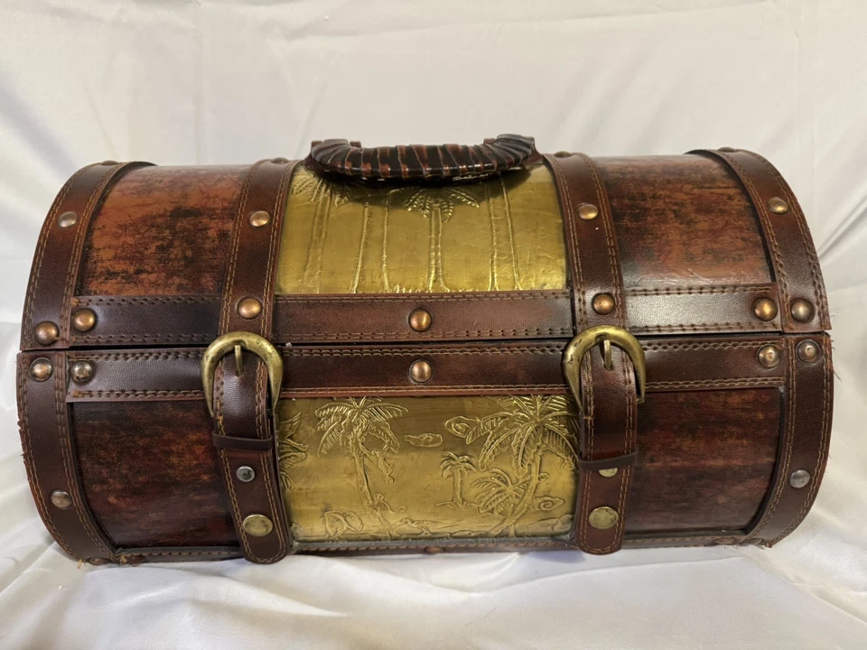 Cofre del tesoro vintage con adornos de latón y cierre de correa de cuero. Foto 1 de 4