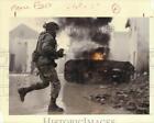 1988 Press Photo Soldier sprints past burning car at Fort Hood - hpm02063