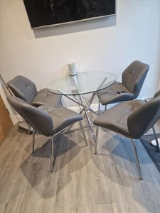 Round Glass dining table with four grey chairs - Picture 1 of 5