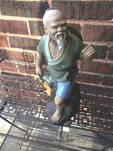  FIGURA DE CERÁMICA DE ARCILLA DE PESCADO DE HOMBRE ORIENTAL SOSTENIENDO  - Imagen 1 de 2