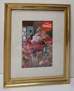 Tarjeta de felicitación de Navidad de Coca-Cola 1997 enmarcada con Santa y elfos en el taller - Imagen 1 de 6