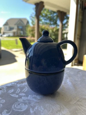 Tetera de cerámica azul oscuro en una taza para uno sin marca Foto 1 de 2