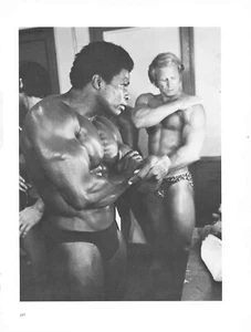 African American & Caucasian Bodybuilder Oil Up Before Competition - Picture 1 of 1