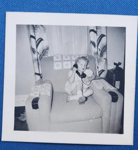Kleines Mädchen spricht am schwarzen Telefon sitzend auf Stuhl s/w Foto Schnappschuss 1954 - Bild 1 von 2