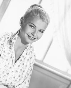 Mary Peach wearing a white floral print blouse smiling in a studio- Old Photo