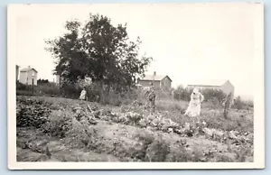 RPPC Frau in Haube hackt im Garten kleines Mädchen beobachtet Postkarte - Bild 1 von 2
