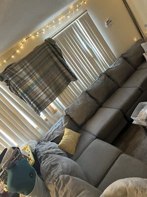 used sectional sofa couch gray in color with two pillows  - Image 1 of 4
