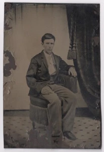 Sitzender junger Mann im Anzug, gestreifte Hose, um 1860er-1870er Jahre Ära, Studio Farbfoto - Bild 1 von 2