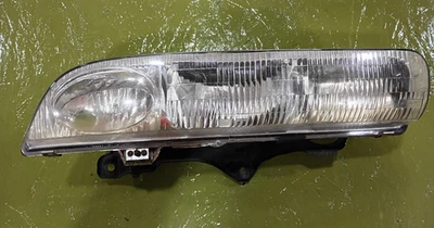 96-99 Saturn Sl1, SL2, SW1, SW2 Left Drivers OEM Headlight Assembly w/Bracket - Image 1 of 4