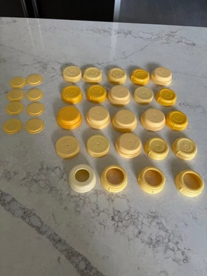 20 tapas estándar de almacenamiento de leche y biberón amarillo Medela + 4 anillos 6 discos Foto 1 de 3