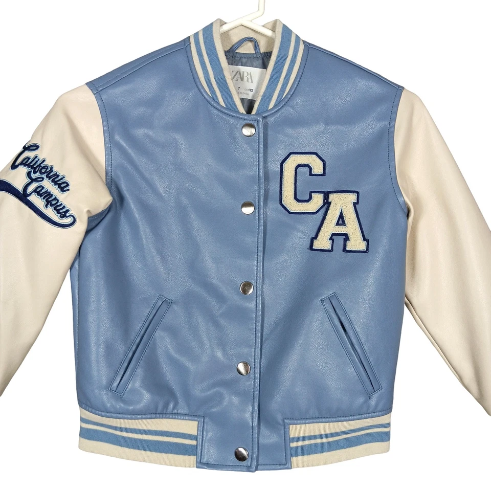 Chaqueta Bomber Universitaria Zara Imitación Cuero Niños Talla 7 Azul Claro y Blanco Foto 1 de 4