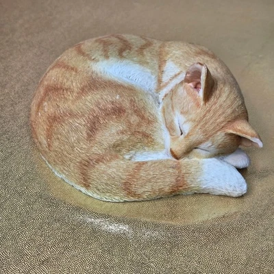 Estatua atigrada durmiente de gato acostado, oreja astillada naranja Foto 1 de 4